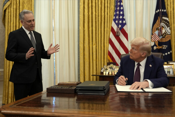 On January 23, in the Oval Office of the White House in Washington, DC, President Donald Trump (right) is listening to the story of White House Advisor David Sachs while signing an executive order related to cryptocurrencies. AP Yonhap News