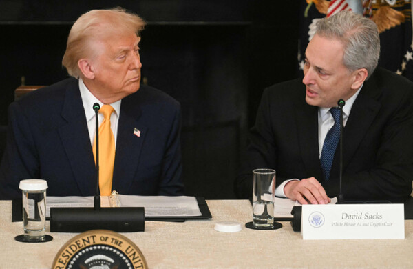 Donald Trump, the US President, listens to David Sachs (right), the White House AI and Cryptocurrency Policy Director, at the 'White House Cryptocurrency Summit' held at the White House in Washington D.C. on March 7th. AFP Yonhap News