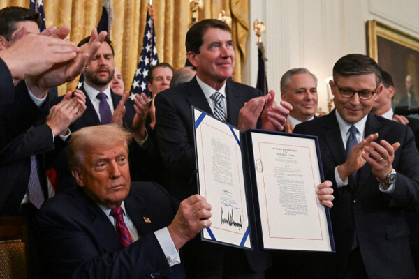 Donald Trump, the US President, holds up a document after signing the 'Genius Act' at the White House in Washington D.C. on the 18th (local time), which establishes a regulatory framework for stablecoin cryptocurrencies and expands industry oversight. Reuters-Yonhap News